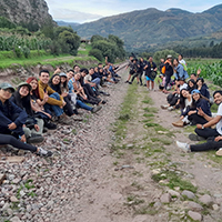 Jovenes sentados en un campo, generando un camino entre ellos