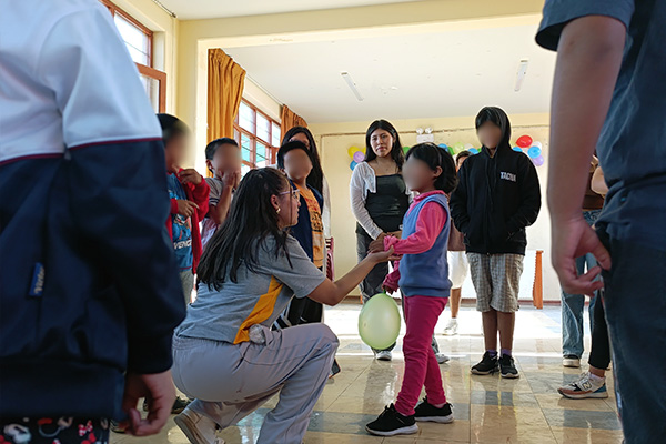 Mujer jugando con una niña y un globo